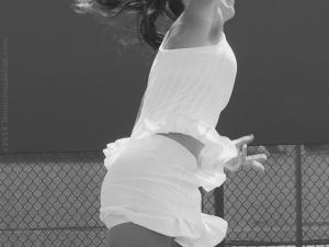 Jelena Jankovic leaping serve white ruffled dress
